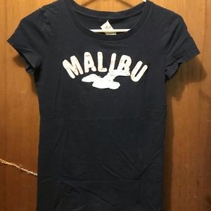 navy blue shirt Light pink letters. White seagull